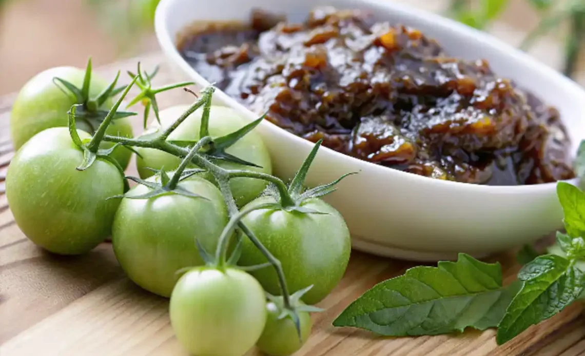 "Ingrédients frais pour préparer la confiture de tomates vertes sur un comptoir en bois rustique."
